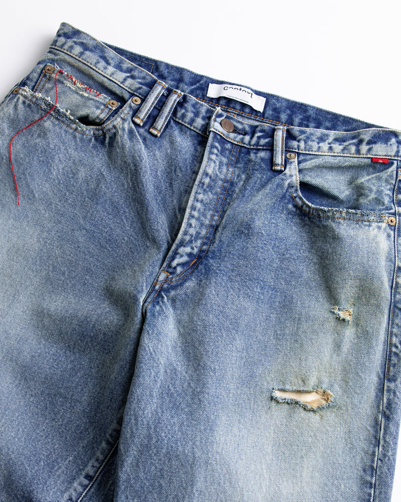 1985年登場のLEVIS 550をベースにリファインしたワイドテーパードパンツ。14ozの「ハチマル」デニムを再現し、10年間の着用を想定した淡色エイジングを施しました。ダメージリペアと最終工程の汚し加工を加えることで、長年穿き込まれたヴィンテージの風格をリアリティたっぷりに表現。空紡糸のドライな質感と、徹底したリメイクが光る一着です。

Wide tapered pants refined from the 1985 LEVIS 550, made from 14oz "Hachimaru" denim. The "Ten Year" finish delivers a heavily faded light blue, enhanced by meticulous repairs and a final "dirt" tint. These remade pants capture a decade of rugged use, blending a dry-touch texture with a profound, authentic vintage character.
