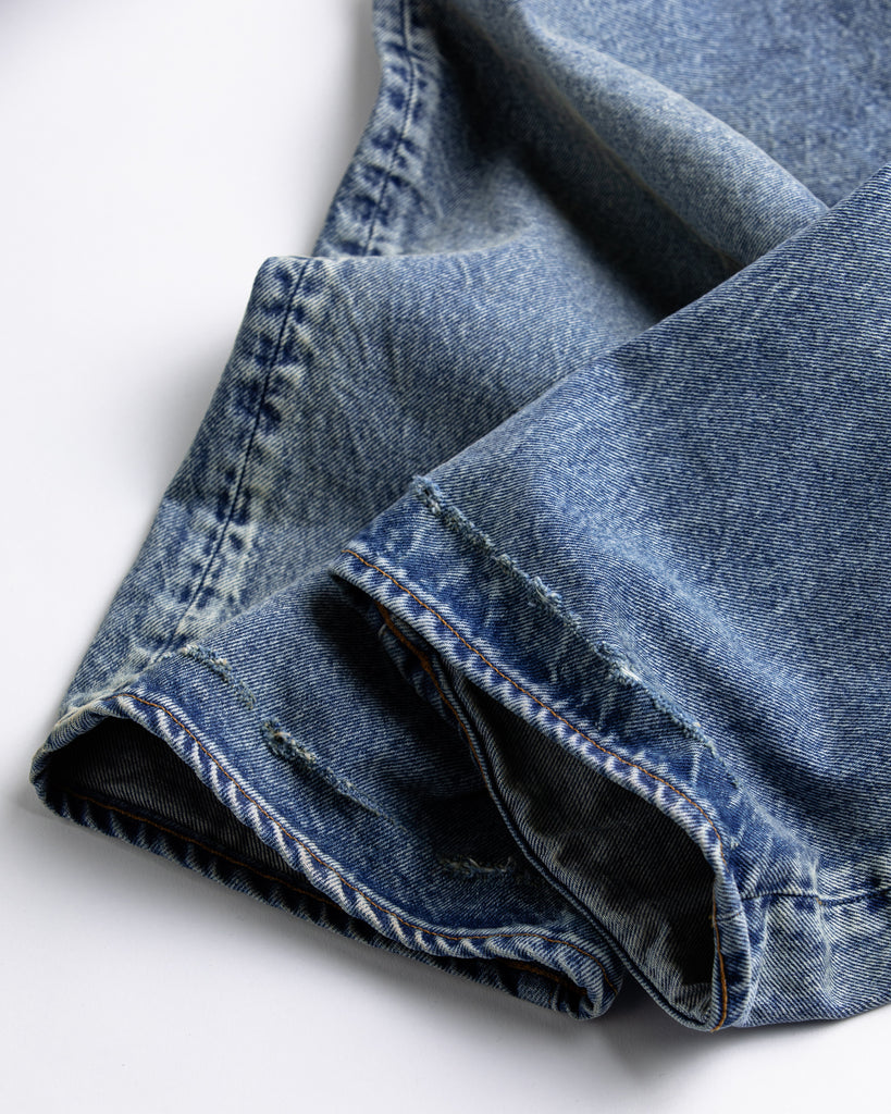 1985年登場のLEVIS 550をベースにリファインしたワイドテーパードパンツ。耳なし移行期の「ハチマル」デニムを再現し、14ozの肉厚でフラットな表情を活かしました。5年間の高頻度な着用を想定した加工により、ダイナミックな色落ちとハードなアタリを表現。80年代の空気感と力強いエイジングが融合した一本です。

Wide tapered pants refined from the 1985 LEVIS 550. Made from 14oz "Hachimaru" denim, reproducing the flat texture of the non-selvedge era. The "Five Year" aging finish delivers heavy fading and bold wear patterns, capturing a rugged, high-frequency use aesthetic. This piece masterfully combines 80s heritage with a powerful, broken-in character.