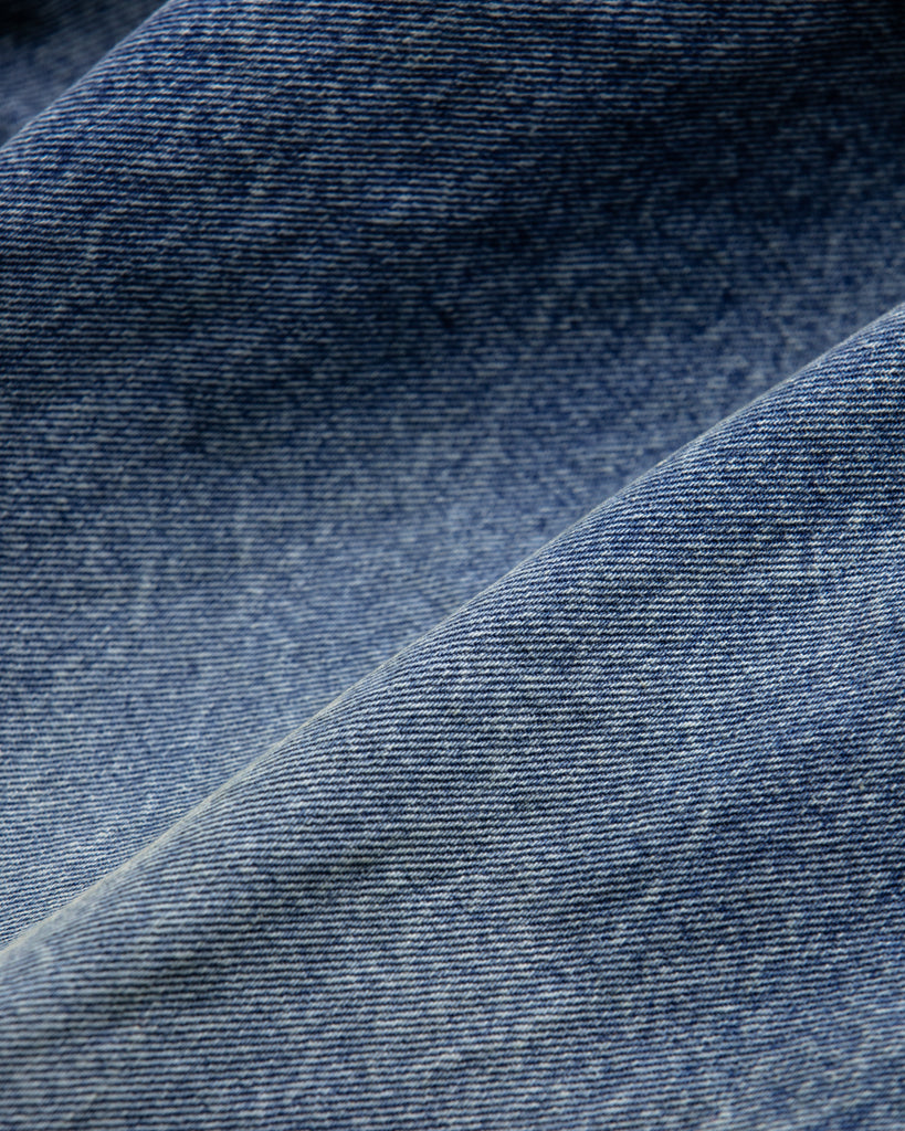 1985年登場のLEVIS 550をベースにリファインしたワイドテーパードパンツ。14ozの「ハチマル」デニムを再現し、10年間の着用を想定した淡色エイジングを施しました。ダメージリペアと最終工程の汚し加工を加えることで、長年穿き込まれたヴィンテージの風格をリアリティたっぷりに表現。空紡糸のドライな質感と、徹底したリメイクが光る一着です。

Wide tapered pants refined from the 1985 LEVIS 550, made from 14oz "Hachimaru" denim. The "Ten Year" finish delivers a heavily faded light blue, enhanced by meticulous repairs and a final "dirt" tint. These remade pants capture a decade of rugged use, blending a dry-touch texture with a profound, authentic vintage character.