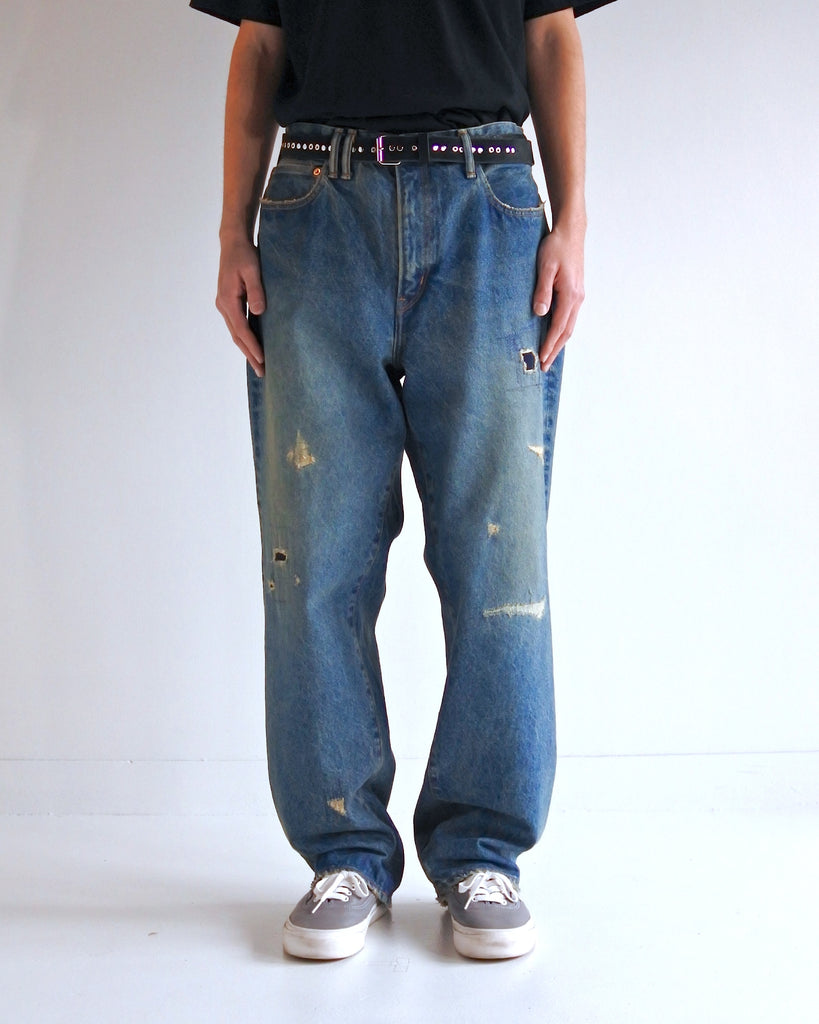 1985年登場のLEVIS 550をベースにリファインしたワイドテーパードパンツ。14ozの「ハチマル」デニムを再現し、5年間の高頻度な着用を想定したエイジングを施しました。精巧なダメージリペアと最終工程の汚し加工を加えることで、中濃色のブルーにヴィンテージ特有の深みをプラス。空紡糸のドライな質感と、徹底したリメイクが融合した存在感のある一着です。

Wide tapered pants refined from the 1985 LEVIS 550, using 14oz "Hachimaru" denim. The "Five Year" finish features mid-tone fading and bold wear, enhanced by realistic repairs and a final "dirt" tint. These remade pants offer a rugged, authentic character, blending 80s heritage with a sophisticated, long-worn aesthetic.