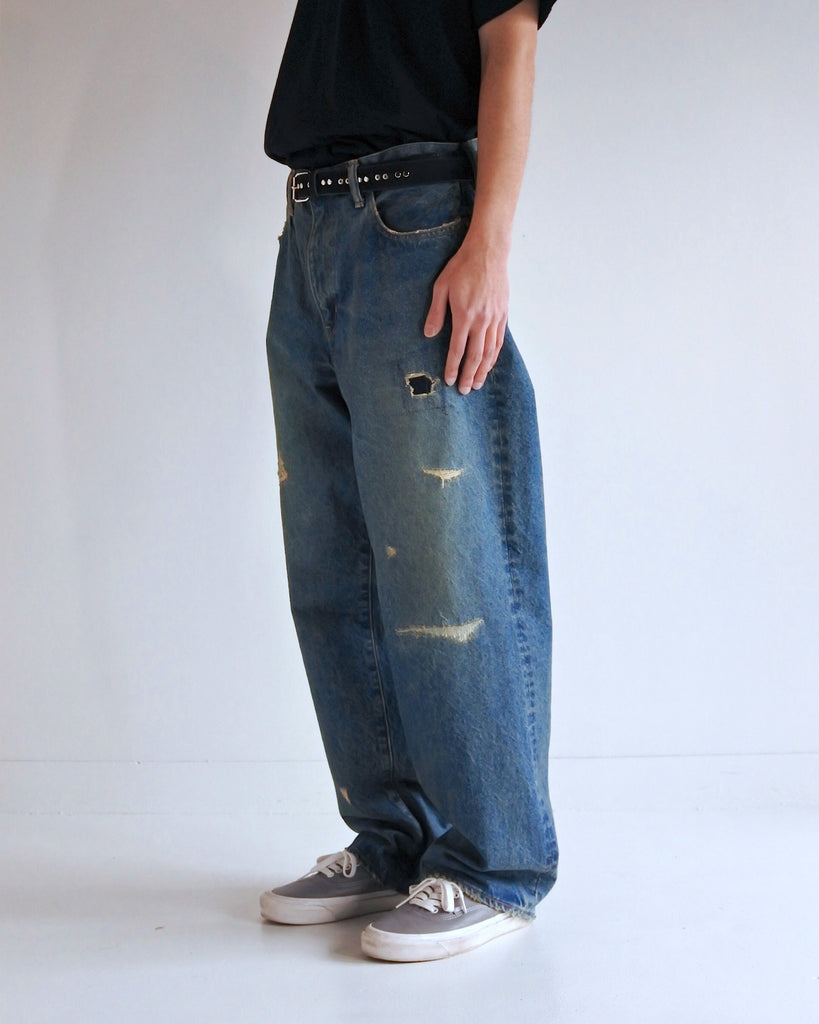 1985年登場のLEVIS 550をベースにリファインしたワイドテーパードパンツ。14ozの「ハチマル」デニムを再現し、5年間の高頻度な着用を想定したエイジングを施しました。精巧なダメージリペアと最終工程の汚し加工を加えることで、中濃色のブルーにヴィンテージ特有の深みをプラス。空紡糸のドライな質感と、徹底したリメイクが融合した存在感のある一着です。

Wide tapered pants refined from the 1985 LEVIS 550, using 14oz "Hachimaru" denim. The "Five Year" finish features mid-tone fading and bold wear, enhanced by realistic repairs and a final "dirt" tint. These remade pants offer a rugged, authentic character, blending 80s heritage with a sophisticated, long-worn aesthetic.