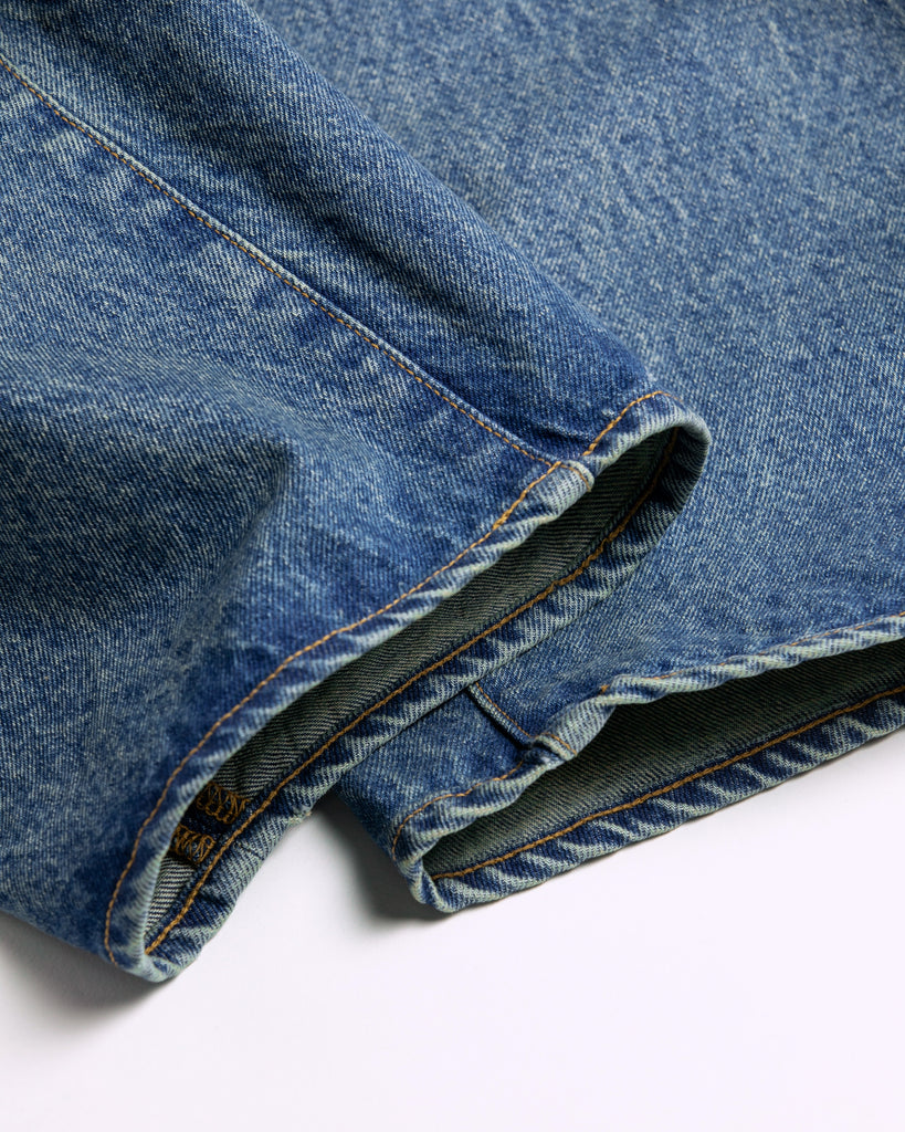 1985年登場のLEVIS 550をベースにリファインしたワイドテーパードパンツ。耳なし移行期の「ハチマル」デニムを再現し、14ozの肉厚でフラットな表情を活かしました。5年間の高頻度な着用を想定した加工により、ダイナミックな色落ちとハードなアタリを表現。80年代の空気感と力強いエイジングが融合した一本です。

Wide tapered pants refined from the 1985 LEVIS 550. Made from 14oz "Hachimaru" denim, reproducing the flat texture of the non-selvedge era. The "Five Year" aging finish delivers heavy fading and bold wear patterns, capturing a rugged, high-frequency use aesthetic. This piece masterfully combines 80s heritage with a powerful, broken-in character.