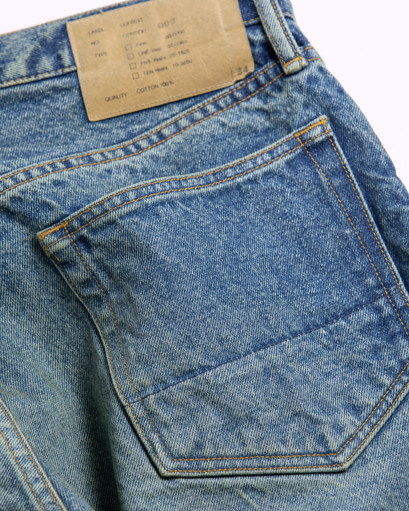 1985年登場のLEVIS 550をベースにリファインしたワイドテーパードパンツ。耳なし移行期の「ハチマル」デニムを再現し、14ozの肉厚でフラットな表情を活かしました。5年間の高頻度な着用を想定した加工により、ダイナミックな色落ちとハードなアタリを表現。80年代の空気感と力強いエイジングが融合した一本です。

Wide tapered pants refined from the 1985 LEVIS 550. Made from 14oz "Hachimaru" denim, reproducing the flat texture of the non-selvedge era. The "Five Year" aging finish delivers heavy fading and bold wear patterns, capturing a rugged, high-frequency use aesthetic. This piece masterfully combines 80s heritage with a powerful, broken-in character.