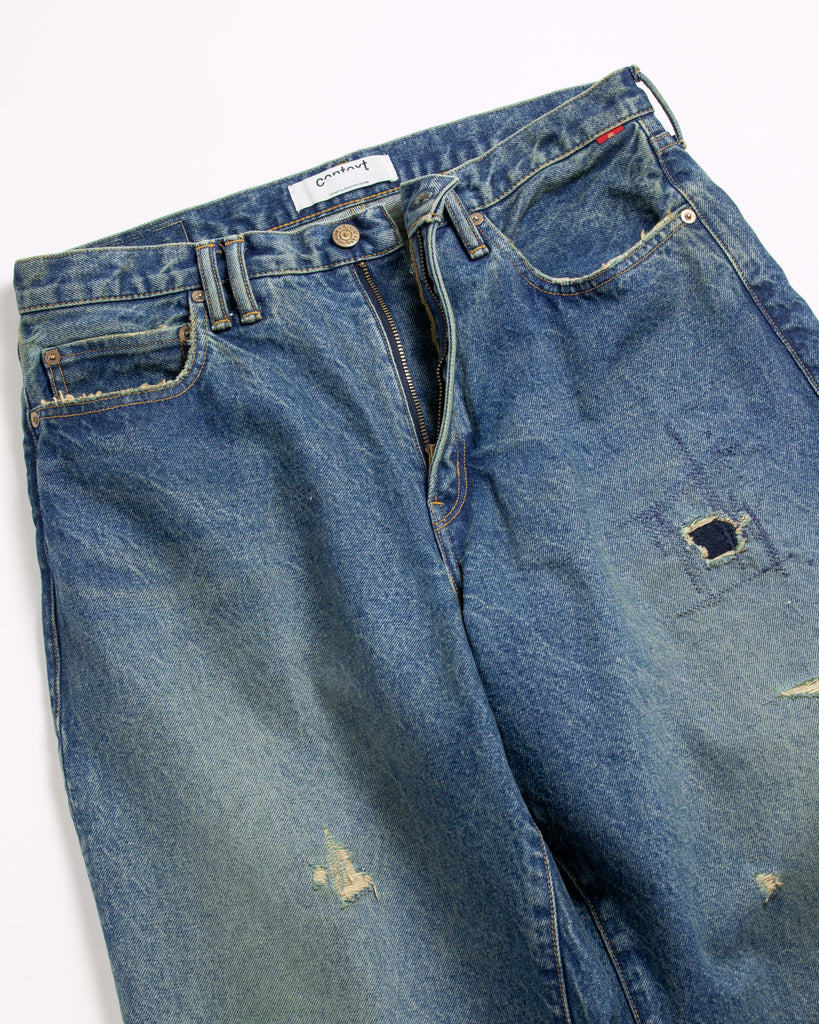 1985年登場のLEVIS 550をベースにリファインしたワイドテーパードパンツ。14ozの「ハチマル」デニムを再現し、5年間の高頻度な着用を想定したエイジングを施しました。精巧なダメージリペアと最終工程の汚し加工を加えることで、中濃色のブルーにヴィンテージ特有の深みをプラス。空紡糸のドライな質感と、徹底したリメイクが融合した存在感のある一着です。

Wide tapered pants refined from the 1985 LEVIS 550, using 14oz "Hachimaru" denim. The "Five Year" finish features mid-tone fading and bold wear, enhanced by realistic repairs and a final "dirt" tint. These remade pants offer a rugged, authentic character, blending 80s heritage with a sophisticated, long-worn aesthetic.