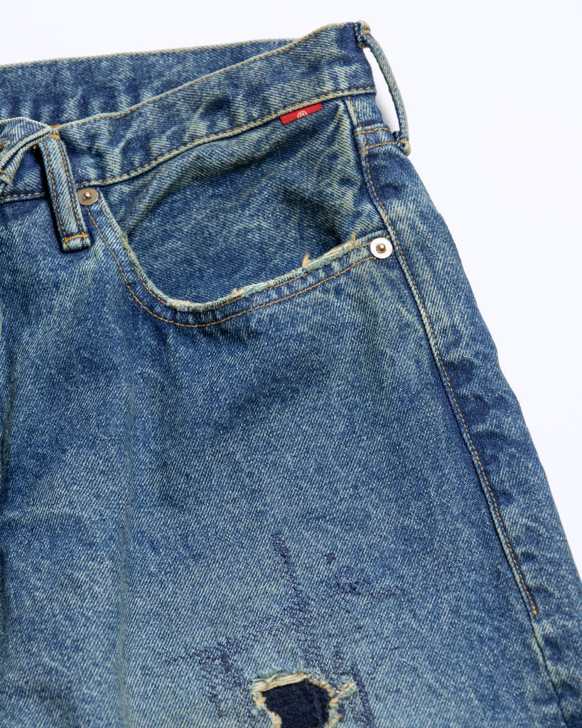 1985年登場のLEVIS 550をベースにリファインしたワイドテーパードパンツ。14ozの「ハチマル」デニムを再現し、5年間の高頻度な着用を想定したエイジングを施しました。精巧なダメージリペアと最終工程の汚し加工を加えることで、中濃色のブルーにヴィンテージ特有の深みをプラス。空紡糸のドライな質感と、徹底したリメイクが融合した存在感のある一着です。

Wide tapered pants refined from the 1985 LEVIS 550, using 14oz "Hachimaru" denim. The "Five Year" finish features mid-tone fading and bold wear, enhanced by realistic repairs and a final "dirt" tint. These remade pants offer a rugged, authentic character, blending 80s heritage with a sophisticated, long-worn aesthetic.