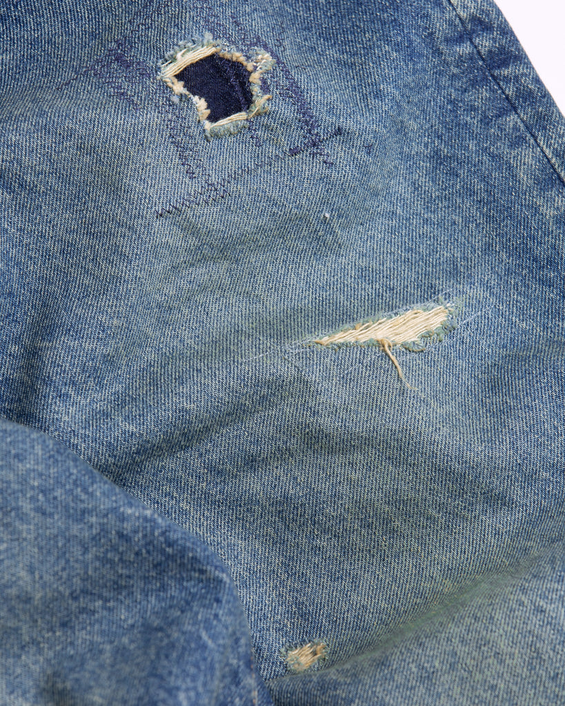 1985年登場のLEVIS 550をベースにリファインしたワイドテーパードパンツ。14ozの「ハチマル」デニムを再現し、5年間の高頻度な着用を想定したエイジングを施しました。精巧なダメージリペアと最終工程の汚し加工を加えることで、中濃色のブルーにヴィンテージ特有の深みをプラス。空紡糸のドライな質感と、徹底したリメイクが融合した存在感のある一着です。

Wide tapered pants refined from the 1985 LEVIS 550, using 14oz "Hachimaru" denim. The "Five Year" finish features mid-tone fading and bold wear, enhanced by realistic repairs and a final "dirt" tint. These remade pants offer a rugged, authentic character, blending 80s heritage with a sophisticated, long-worn aesthetic.