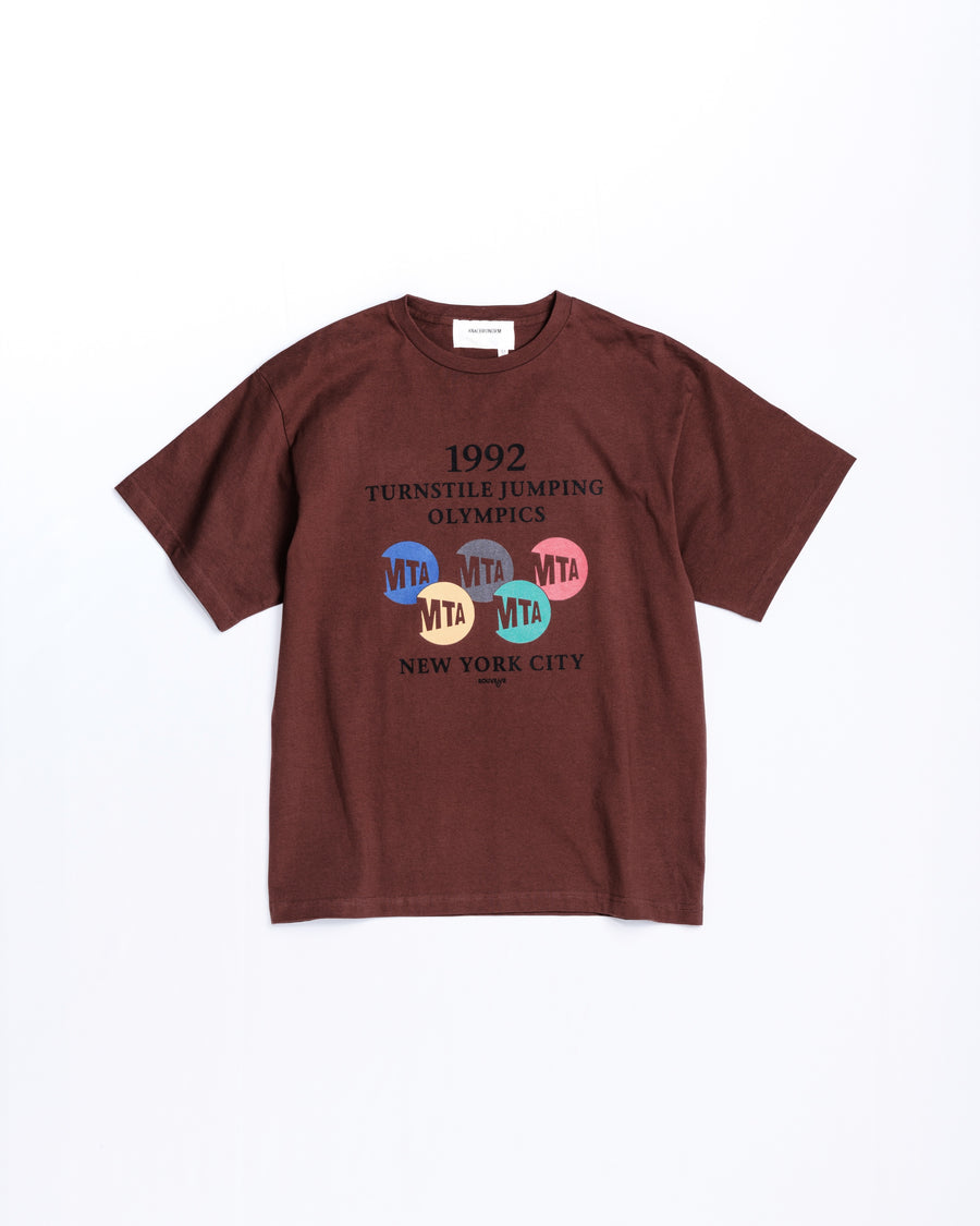ANACHRONORM × Souvenyr NYC ジャンピング 半袖Tシャツ ブラウン | コラボグラフィック ニューヨーク コットン100%
