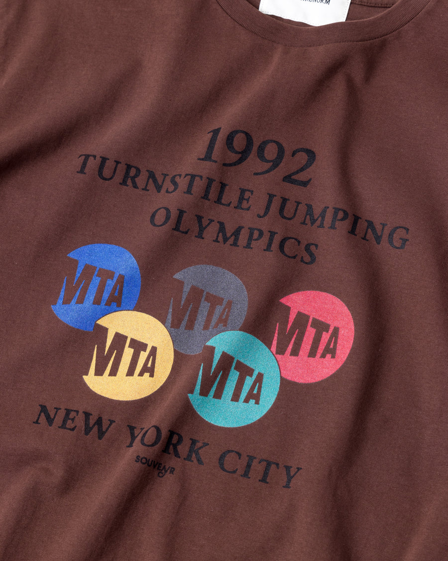 ANACHRONORM × Souvenyr NYC ジャンピング 半袖Tシャツ ブラウン | コラボグラフィック ニューヨーク コットン100%