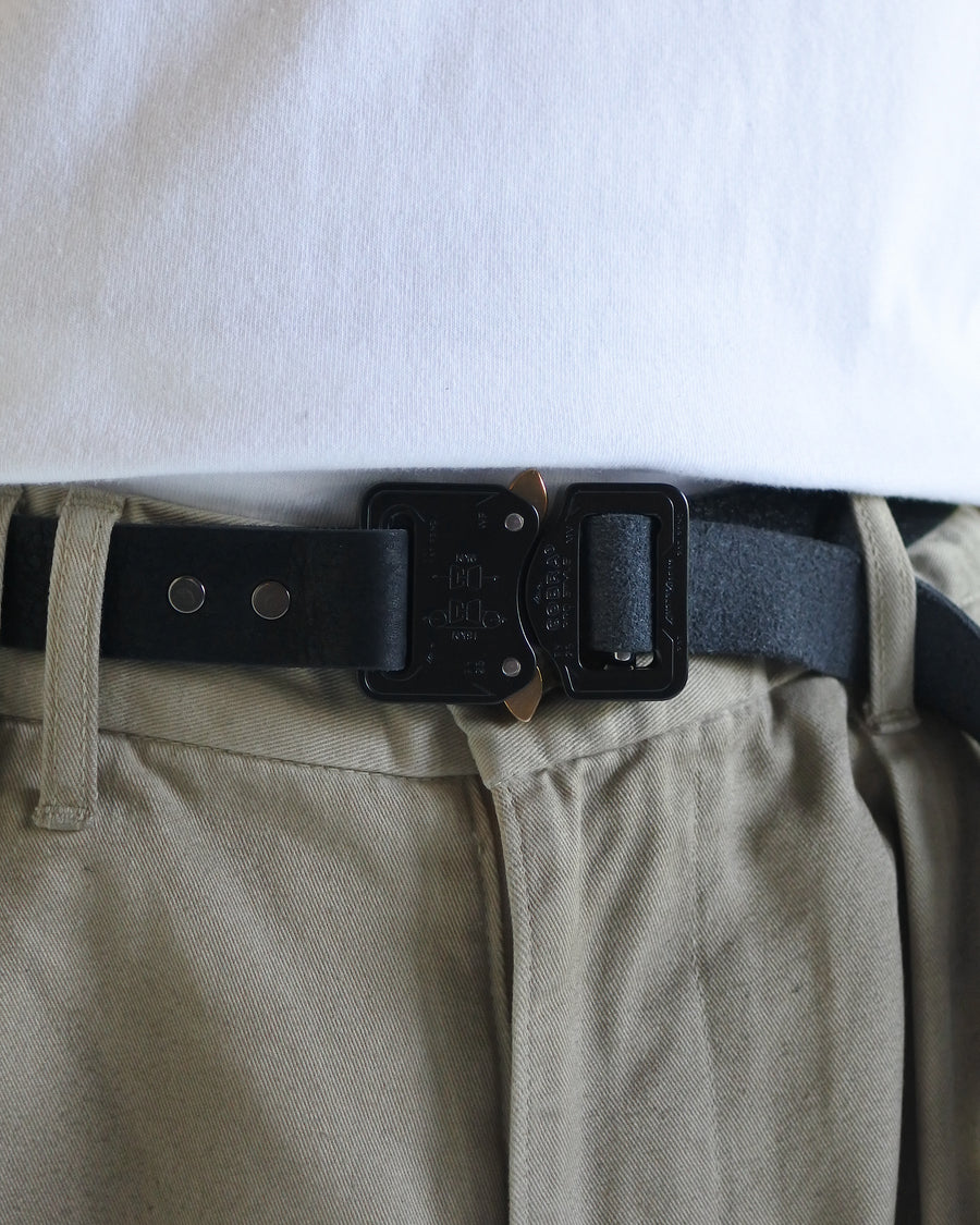 岡山県を拠点とするレザーブランド〈BRASSBOUND〉とのコラボレーションによる「COBRA BUCKLE LEATHER BELT TYPE2」。世界最高水準の安全性と耐久性を誇るコブラバックルを採用し、ワンタッチでの着脱が可能です。ベルト本体にはヌメカウレザーを使用。空打ち加工と吟面の仕上げにより、自然な風合いと経年変化を楽しめる一本に仕上げています。The COBRA BUCKLE LEATHER BELT TYPE2 is a collaboration with the Okayama-based leather brand BRASSBOUND.It features a Cobra Buckle known for world-class safety and durability, allowing quick locking and releasing.