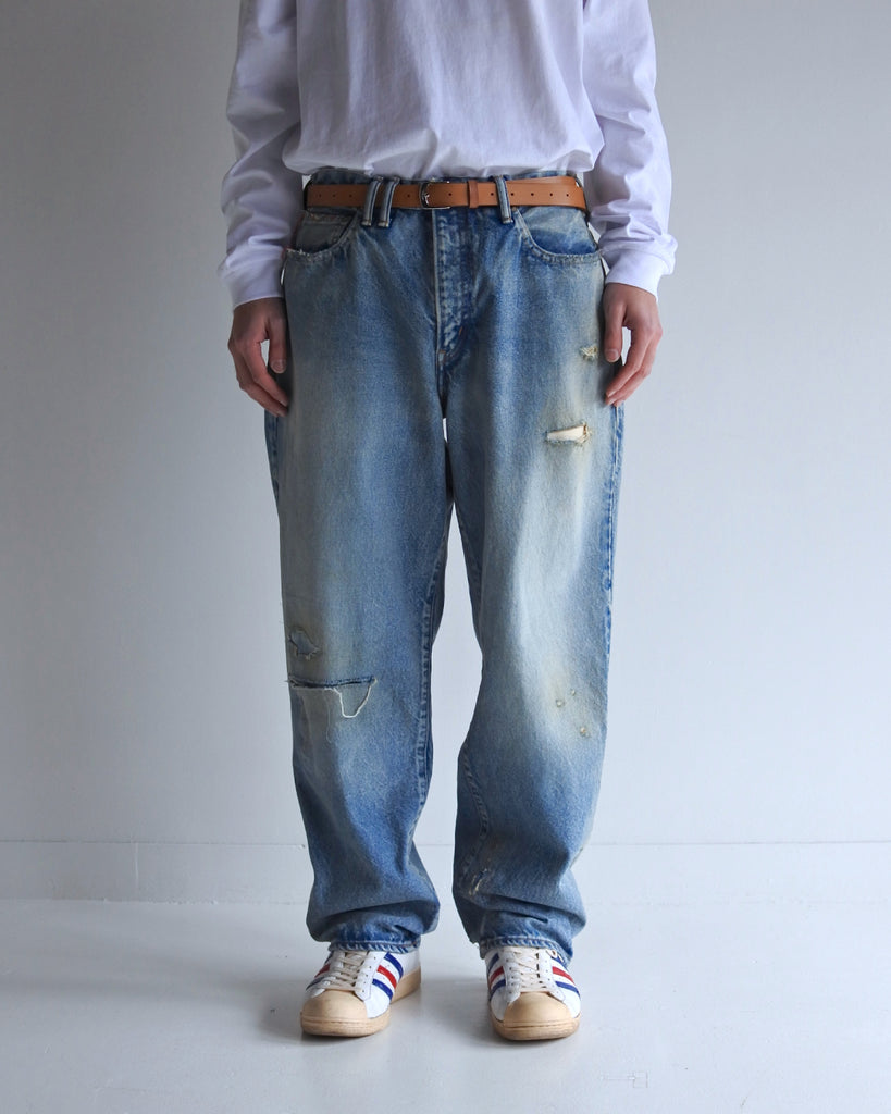 1985年登場のLEVIS 550をベースにリファインしたワイドテーパードパンツ。14ozの「ハチマル」デニムを再現し、10年間の着用を想定した淡色エイジングを施しました。ダメージリペアと最終工程の汚し加工を加えることで、長年穿き込まれたヴィンテージの風格をリアリティたっぷりに表現。空紡糸のドライな質感と、徹底したリメイクが光る一着です。

Wide tapered pants refined from the 1985 LEVIS 550, made from 14oz "Hachimaru" denim. The "Ten Year" finish delivers a heavily faded light blue, enhanced by meticulous repairs and a final "dirt" tint. These remade pants capture a decade of rugged use, blending a dry-touch texture with a profound, authentic vintage character.