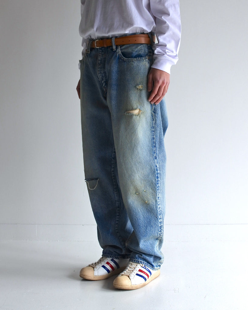1985年登場のLEVIS 550をベースにリファインしたワイドテーパードパンツ。14ozの「ハチマル」デニムを再現し、10年間の着用を想定した淡色エイジングを施しました。ダメージリペアと最終工程の汚し加工を加えることで、長年穿き込まれたヴィンテージの風格をリアリティたっぷりに表現。空紡糸のドライな質感と、徹底したリメイクが光る一着です。

Wide tapered pants refined from the 1985 LEVIS 550, made from 14oz "Hachimaru" denim. The "Ten Year" finish delivers a heavily faded light blue, enhanced by meticulous repairs and a final "dirt" tint. These remade pants capture a decade of rugged use, blending a dry-touch texture with a profound, authentic vintage character.