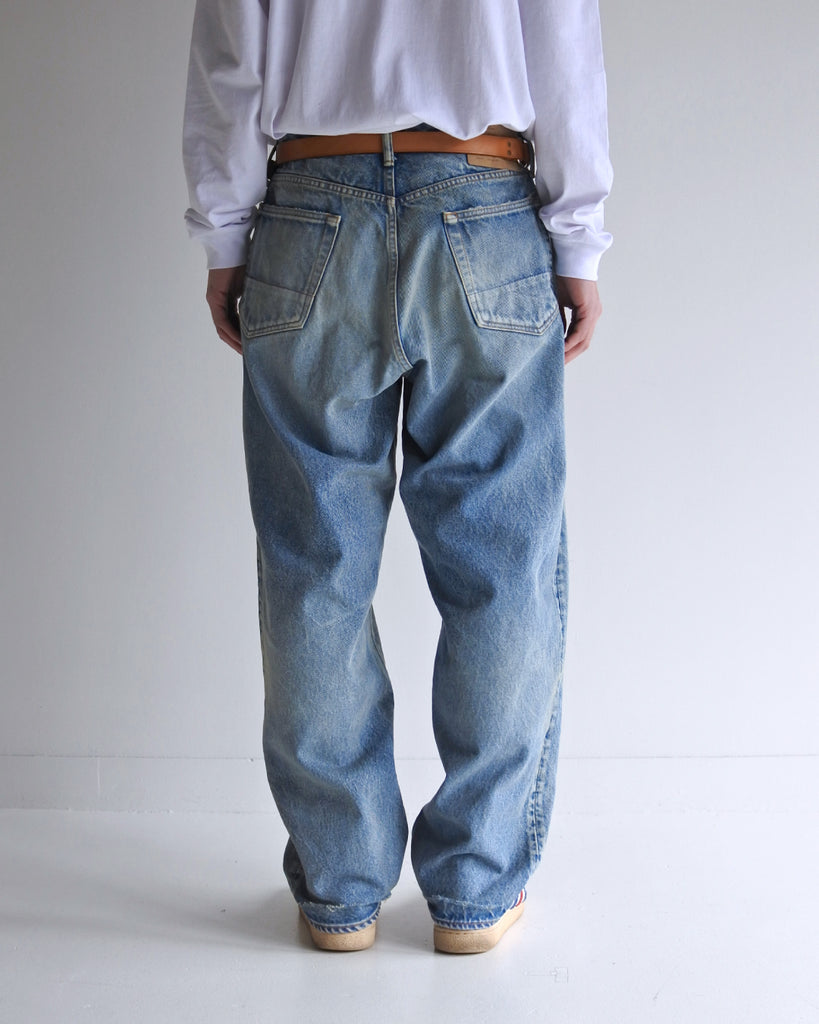 1985年登場のLEVIS 550をベースにリファインしたワイドテーパードパンツ。14ozの「ハチマル」デニムを再現し、10年間の着用を想定した淡色エイジングを施しました。ダメージリペアと最終工程の汚し加工を加えることで、長年穿き込まれたヴィンテージの風格をリアリティたっぷりに表現。空紡糸のドライな質感と、徹底したリメイクが光る一着です。

Wide tapered pants refined from the 1985 LEVIS 550, made from 14oz "Hachimaru" denim. The "Ten Year" finish delivers a heavily faded light blue, enhanced by meticulous repairs and a final "dirt" tint. These remade pants capture a decade of rugged use, blending a dry-touch texture with a profound, authentic vintage character.