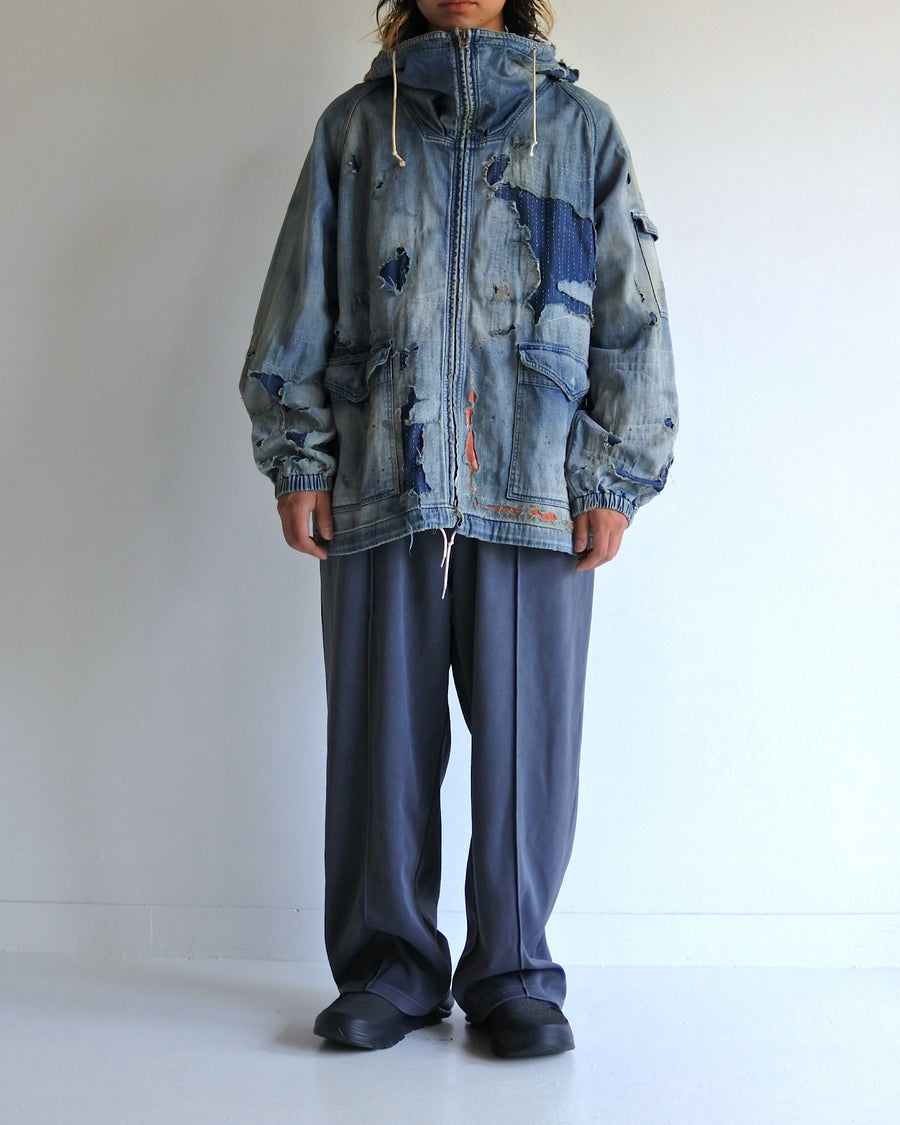ライトオンスデニムを使用し、二重縫製で程よい厚みに仕上げたフルジップパーカー。
経糸にジンバブエコットン100%のムラ糸、緯糸に綿麻混紡糸を使用したデニム生地です。
シャープなムラ感と綿麻特有の粗野な風合いがヴィンテージ感を引き立てます。
エイジング加工後にハードダメージを施し、手作業のステッチワークで補修したリメイク仕様です。
A full-zip parka made from lightweight denim with double stitching for balanced structure.
Crafted from Zimbabwe cotton denim with slub yarn in the warp and a cotton/hemp blend weft.
The sharp irregular texture and rugged feel enhance its vintage-inspired character.
Finished with aging and heavy distressing, then hand-repaired with detailed sti