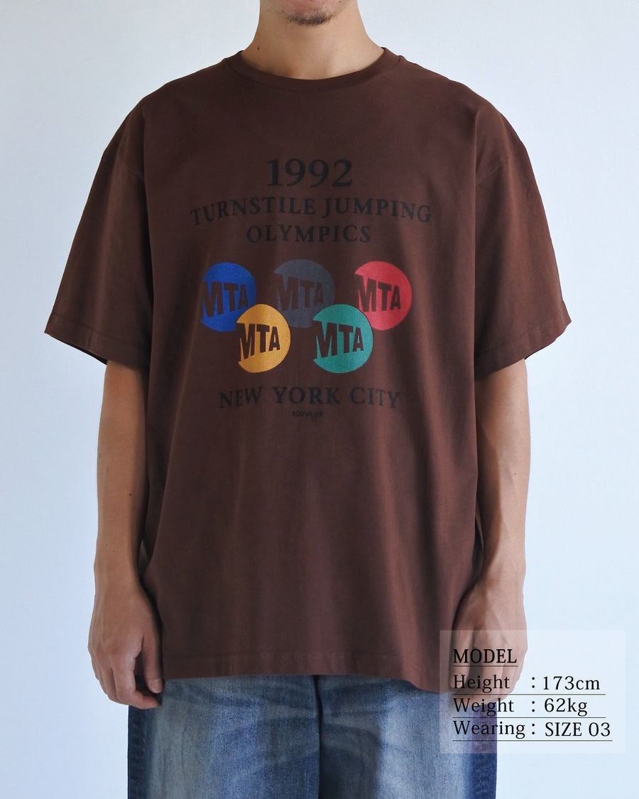 ANACHRONORM × Souvenyr NYC ジャンピング 半袖Tシャツ ブラウン | コラボグラフィック ニューヨーク コットン100%